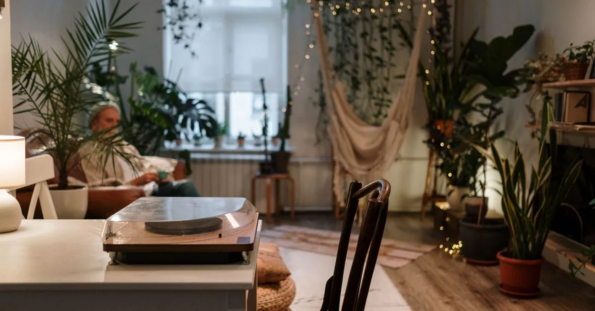 Un salon confortable avec des plantes, un hamac et une platine vinyle vintage, parfait pour la détente.